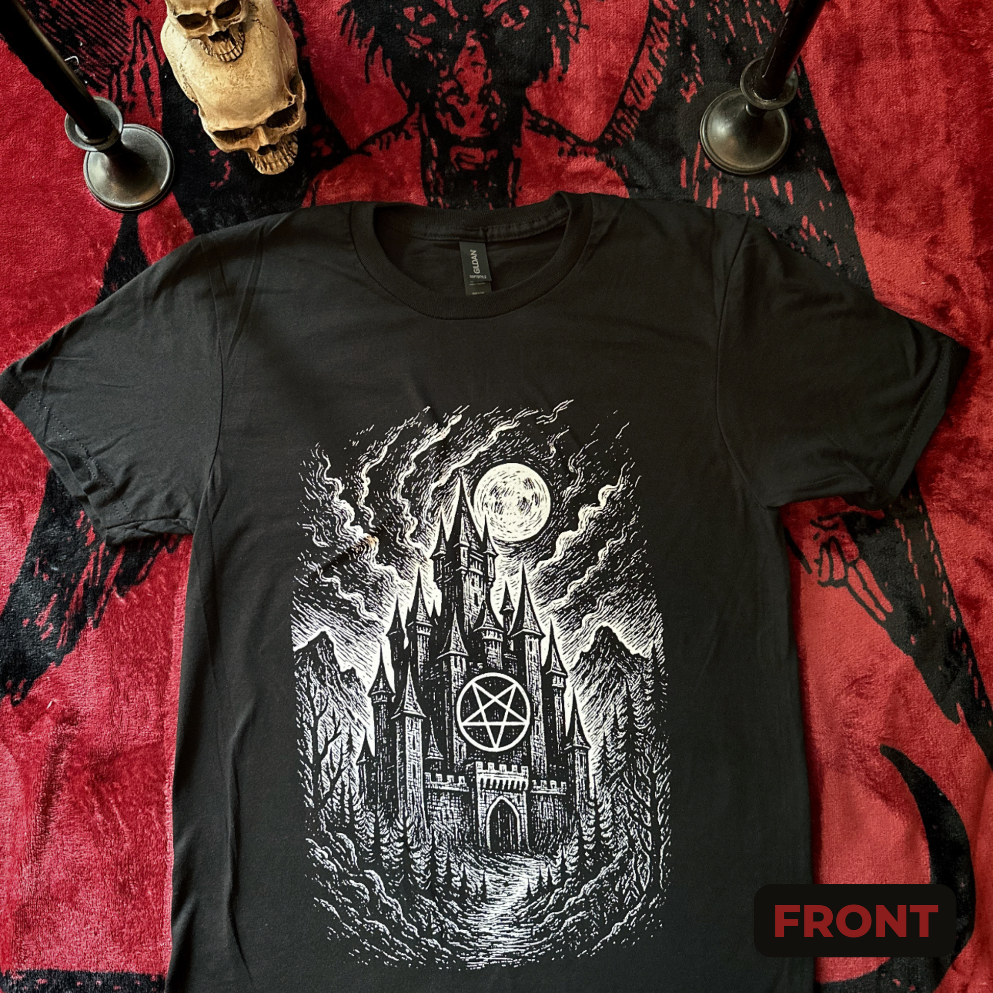 Tee features a white graphic of a gothic style castle with an inverted pentagram below a moon in a dark sky.