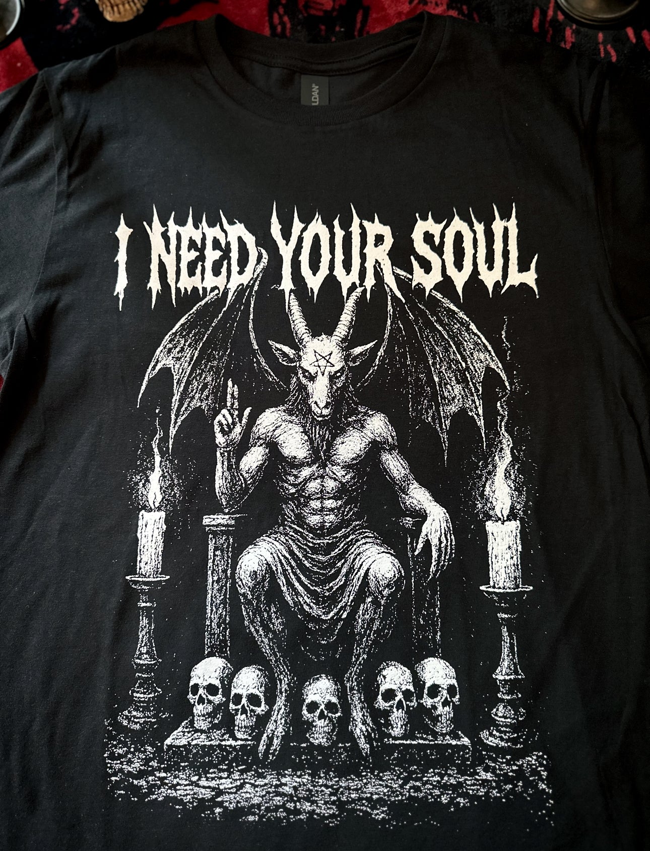 Black t-shirt with a graphic design featuring a satanic figure and text 'I Need Your Soul' on a dark background.