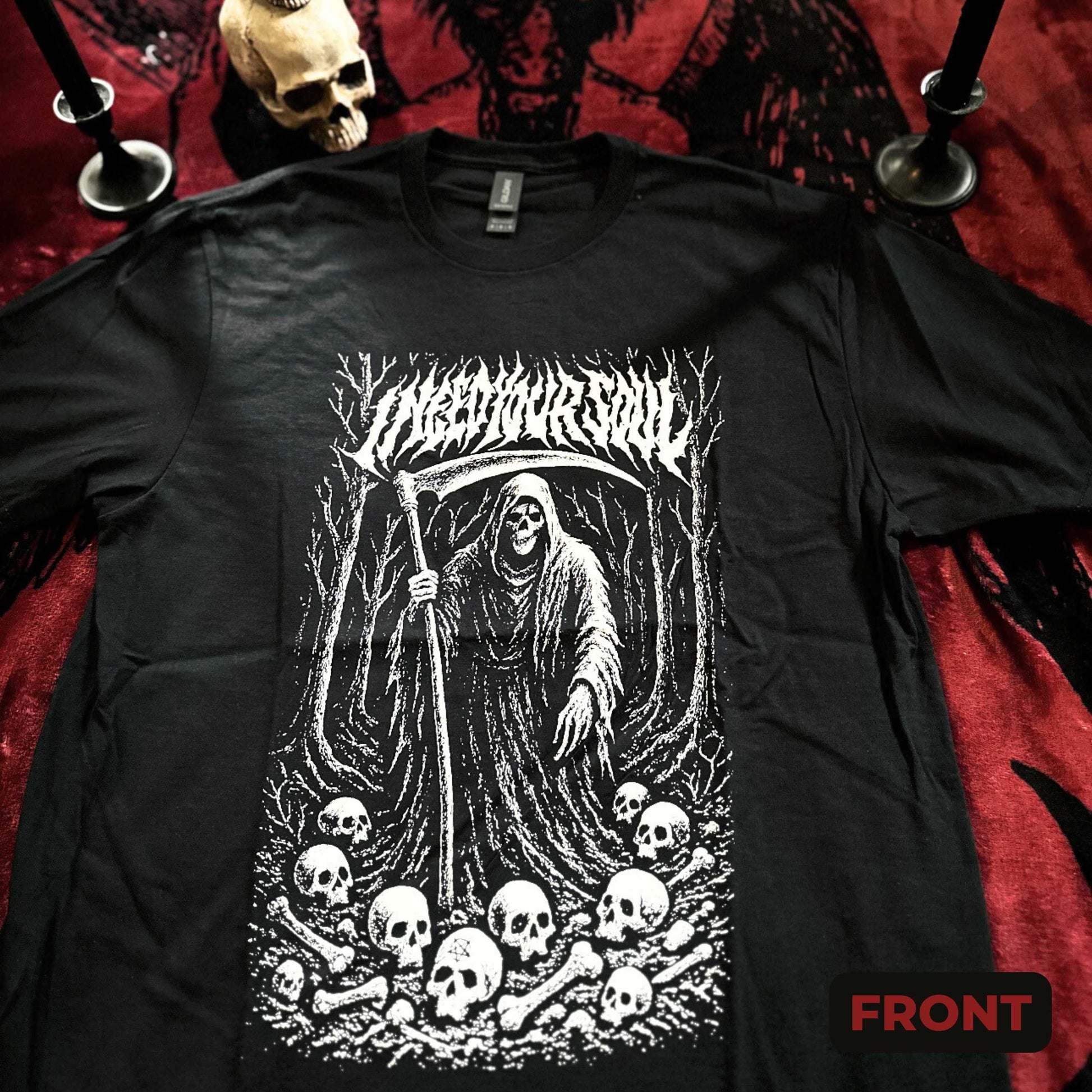 Black long-sleeve shirt with a graphic design of a skeleton holding a scythe and surrounded by skulls on a red fabric background.